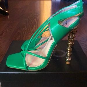 Green open-toe shoe with gold detailed heel.